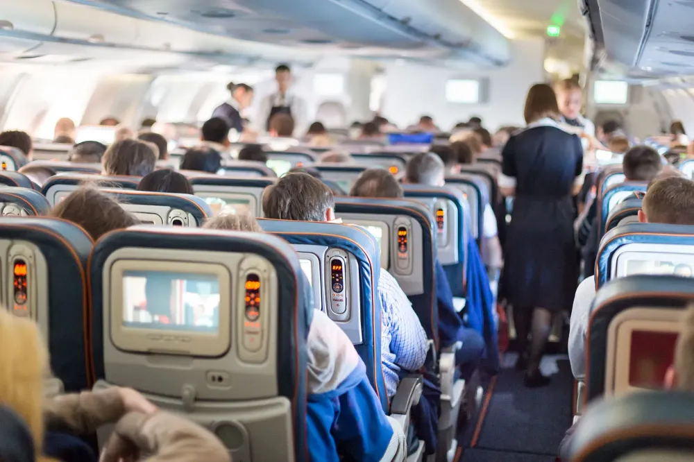 flight attendant moving through airplane cabin